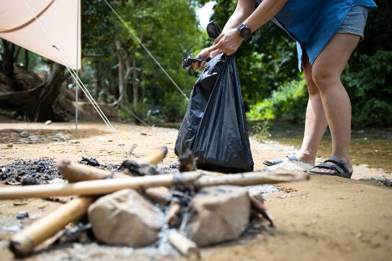 Les Asiatiques ramassent les déchets avec un sac à ordures dans le parc national, les touristes ramassent les déchets en camping-car