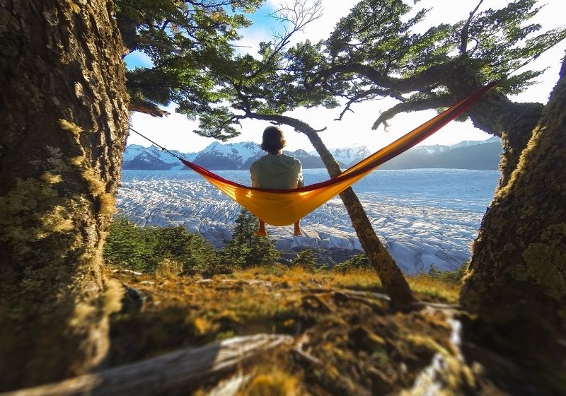 Un jeune homme aux pieds nus est assis dans un hamac orange | Liste d'équipement de Wanderlust fait maison | XX choses que vous devriez avoir dans votre liste d'équipement de sentier des Appalaches