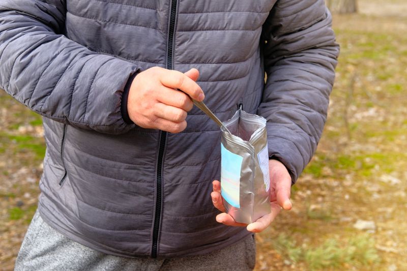 backpacker-manger-aliments-lyophilisés-pendant le chauffage d'urgence 