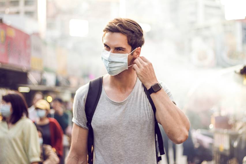 Jeune bel homme marchant autour du marché de nuit à Taipei | La pollution de l'air